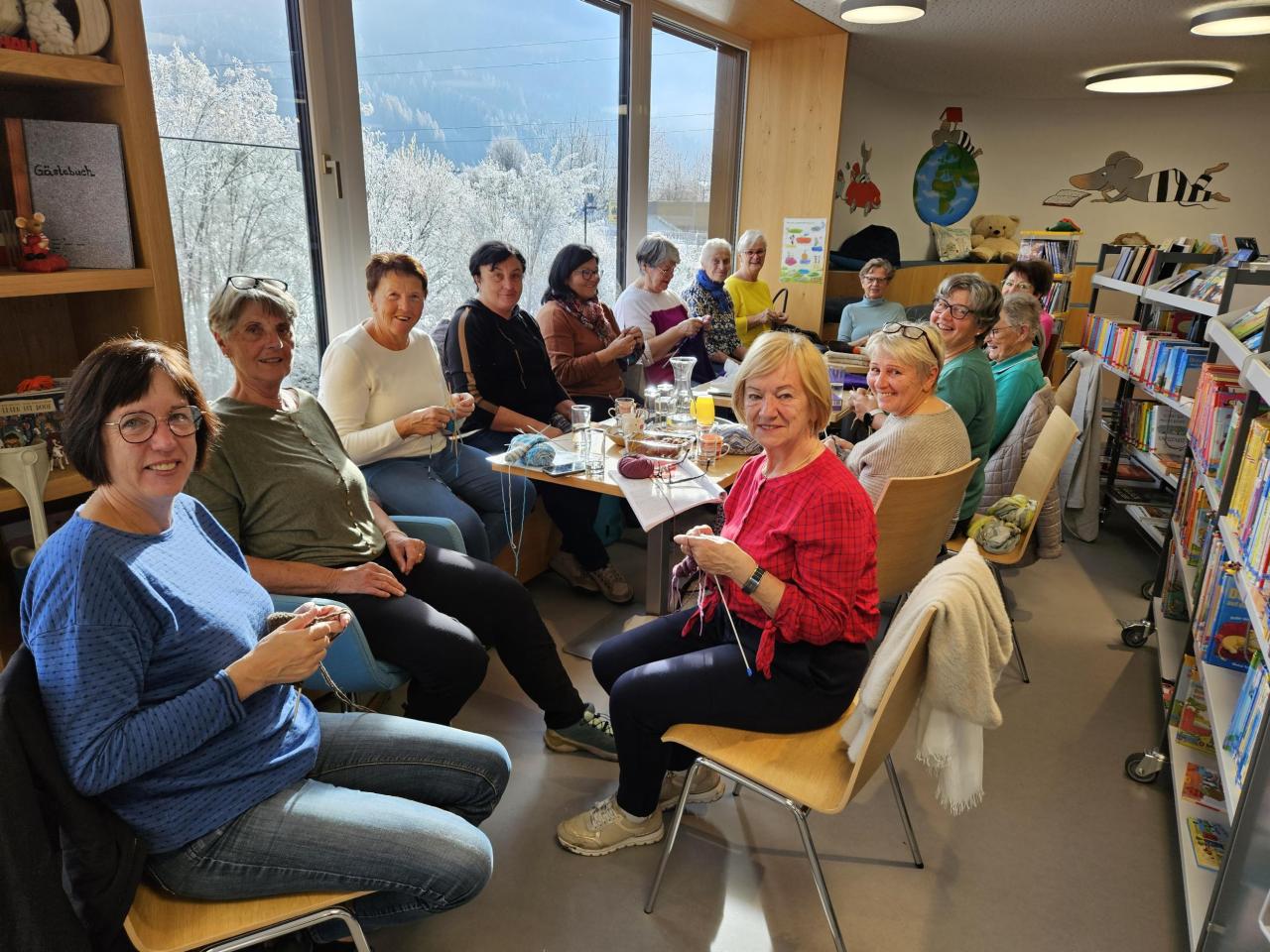 Mehrere Damen sitzen in der Bücherei beim Stricken